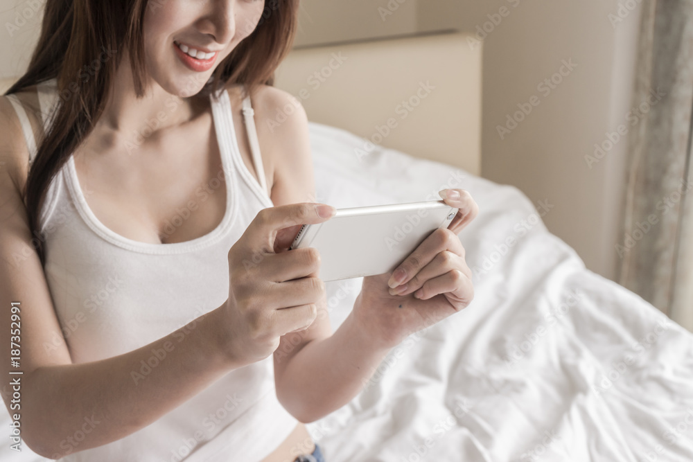 Midsection Of Woman Using Mobile Phone On Bed Midsection Of Woman Using Mobile Phone On Bed