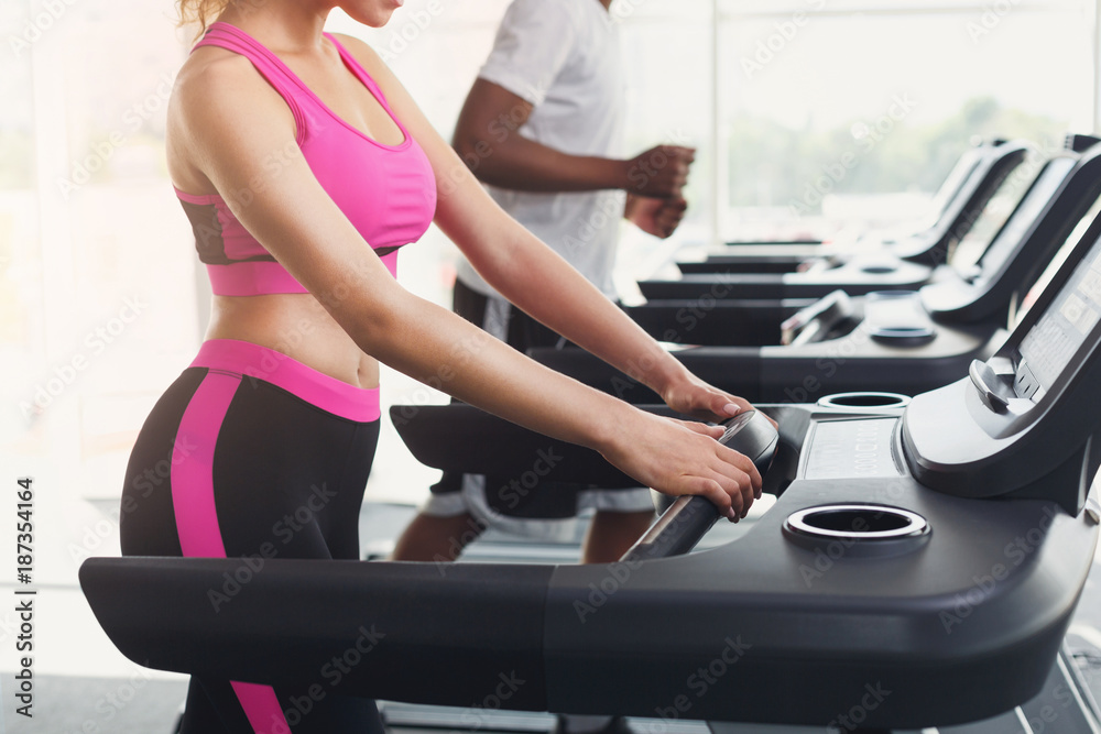Man and woman, couple in gym on treadmills Man and woman, couple in gym on treadmills