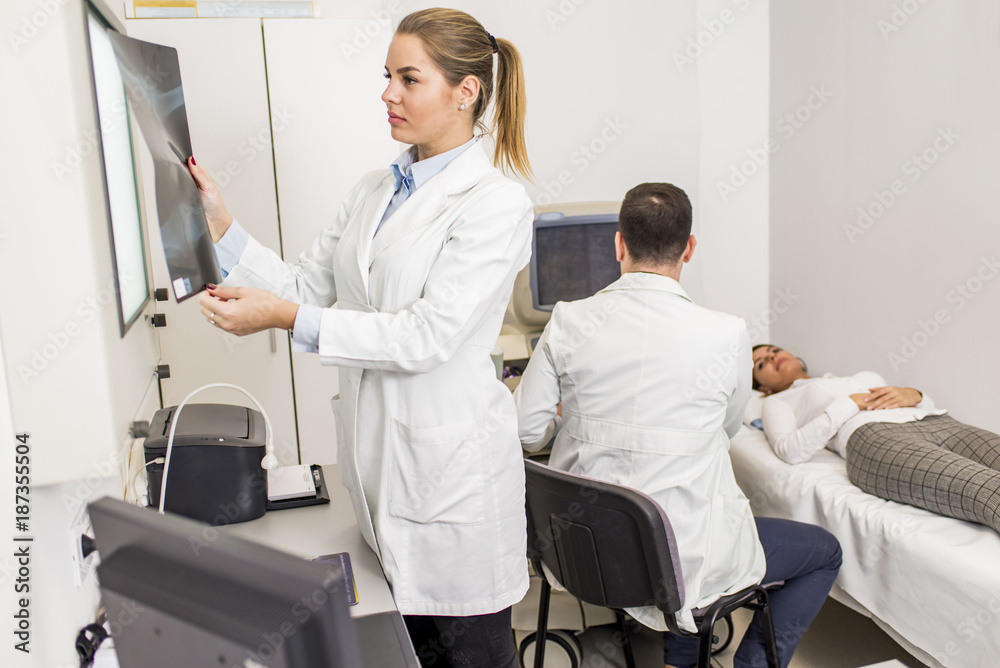 Obraz premium Young female doctor looking at x-ray image