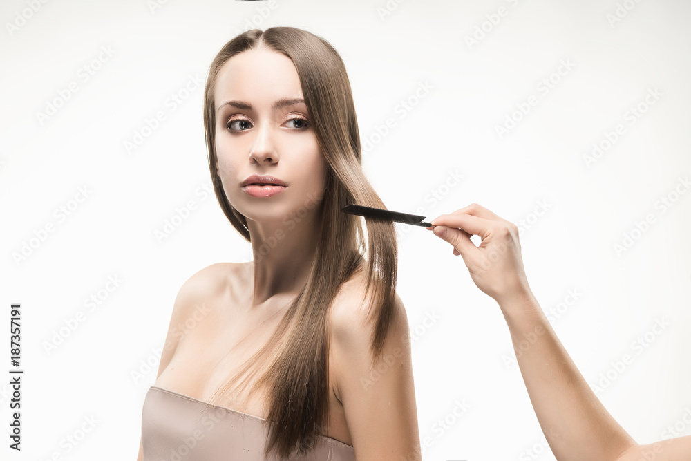 Obraz premium Beautiful young long-haired girl brushed by the stylist.