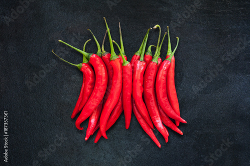 Group of red chili peppers isolated on dark gray slate