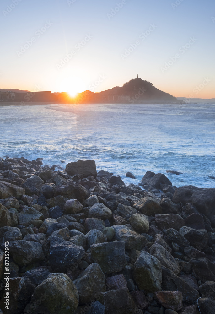 Waves on the coast of the city of Donostia at sunset.