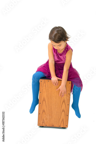 Little girl playing with a cajon isolated on white background photo