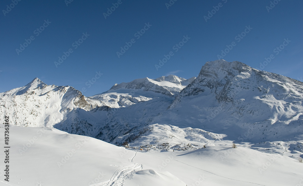 high mountain landscape, photo from mountain summit, on sunny day, blue sky, after a snowfall, in the background the glacier of Mount Breithorn, Simplon Pass, Alps, winter, cold, Valais, Switzerland