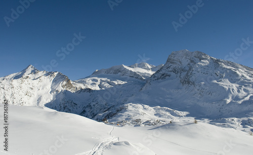 high mountain landscape, photo from mountain summit, on sunny day, blue sky, after a snowfall, in the background the glacier of Mount Breithorn, Simplon Pass, Alps, winter, cold, Valais, Switzerland © Angela
