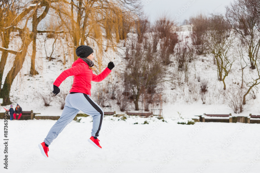 Woman wearing sportswear exercising outside during winter Woman wearing sportswear exercising outside during winter