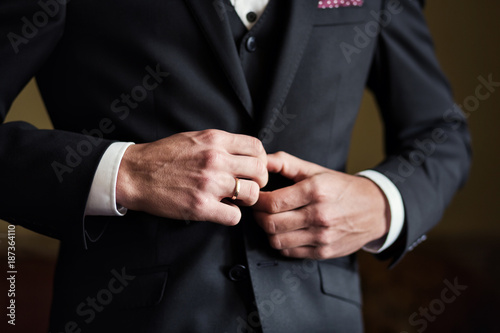 businessman wears a jacket,male hands closeup,groom getting ready in the morning before wedding ceremony