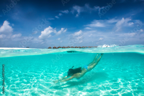 Attraktive Frau im Bikini taucht in klaren, tropischen Gewässern; Sommerurlaubs Konzept