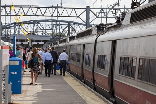 Commuters board a passenger train in a suburban station..