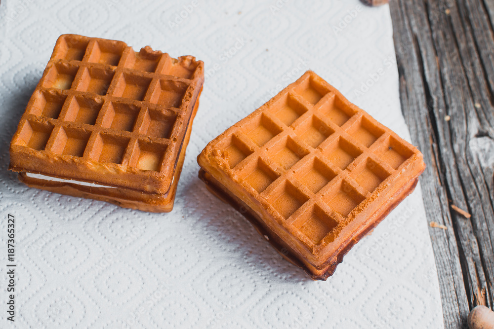 Waffle on a wooden background on a white napkin Waffle on a wooden background on a white napkin