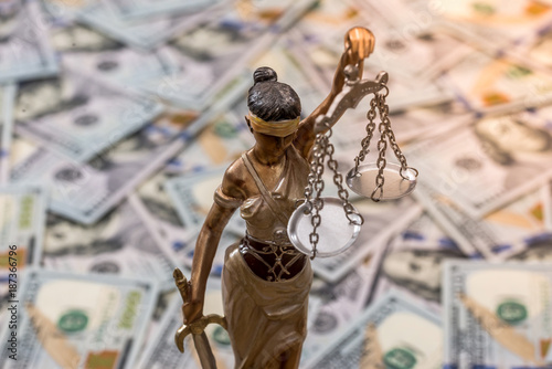 Themis statue standing against the background of dollars