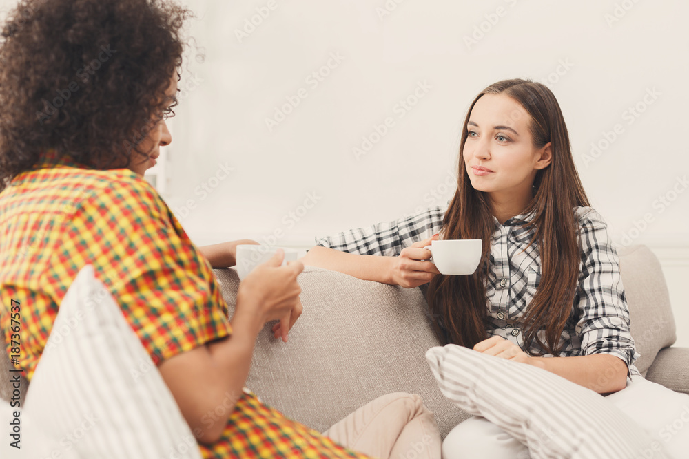 Two young female friends with coffee conversing Two young female friends with coffee conversing