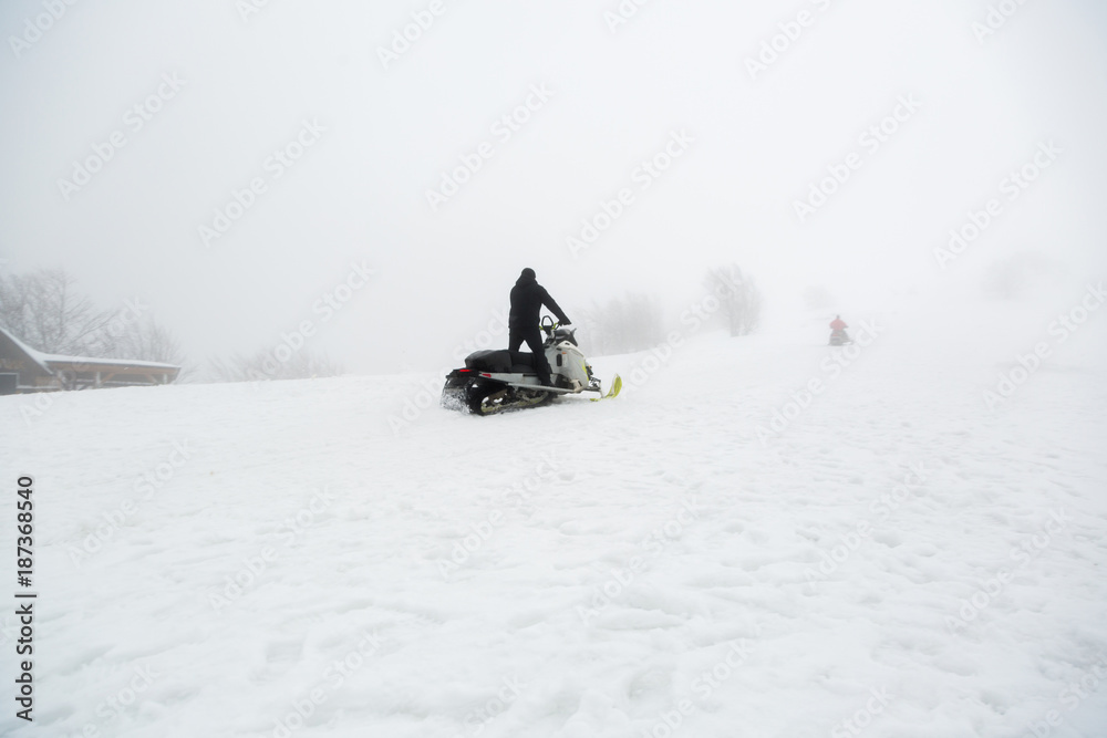 Snowmobile rider goes uphill.