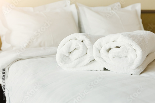 White towels on bed in hotel bedroom closeup