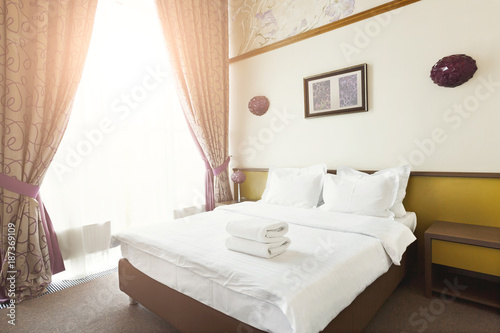 White towels on bed in hotel bedroom