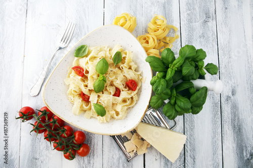 fettucine pasta white cream sauce with tomato and basil in white plate - Italian food style