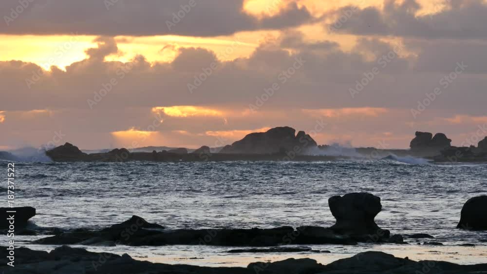 Rough sea on reefs in the evening at sunset, seagulls on the sky. - Mer agitée sur des récifs le soir au coucher du soleil sur un ciel nuageux, des mouettes passent