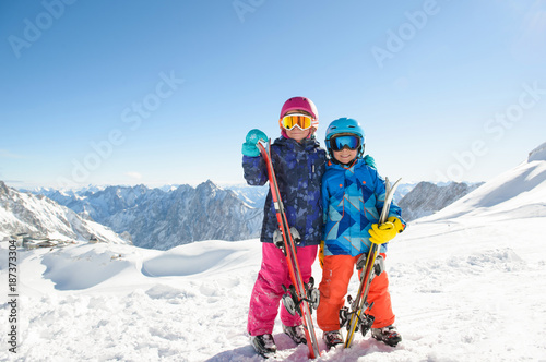 Smiling children enjoying winter vacations in mountains . Ski, Sun, Snow und fun.