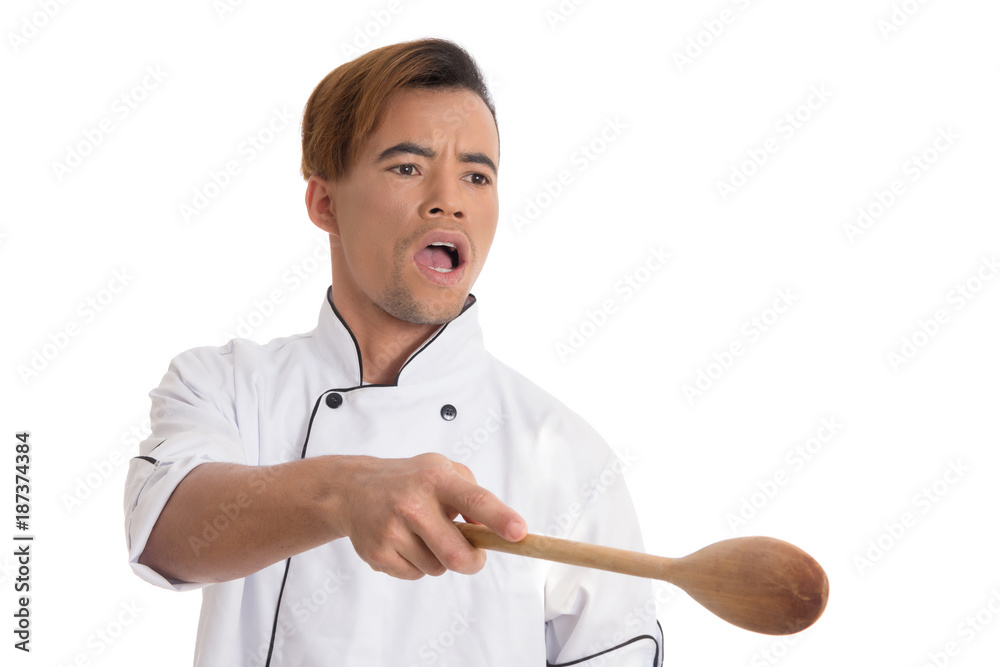 Professional cook pointing with wooden spoon. Young black man is in white cook uniform. Professional cook pointing with wooden spoon. Young black man is in white cook uniform.