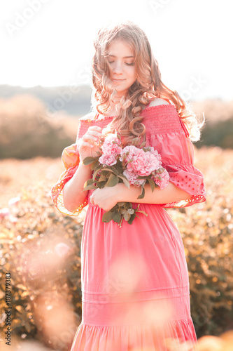 Beautiful blonde teen girl 14-16 year old wearing pink dress holding rose  flower outdoors. Summer portrait Stock Photo - Alamy