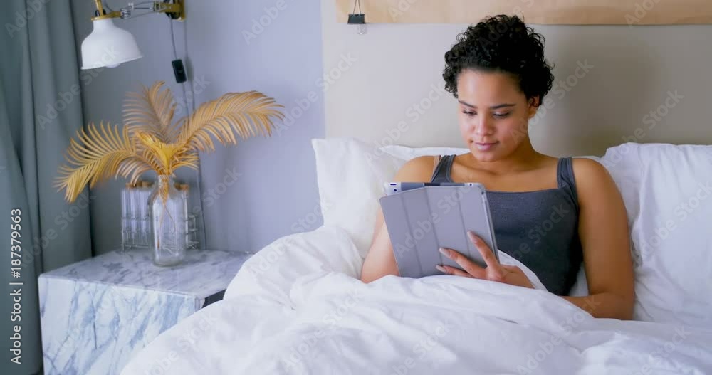 Woman using digital tablet on bed Woman using digital tablet on bed