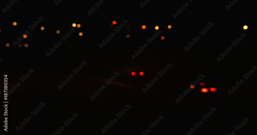 Car light moving on motorway in dark during the night, some driving straight and others taking exit