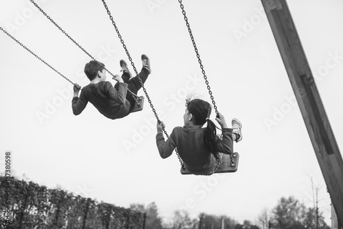 Children flying high in the air on a swing