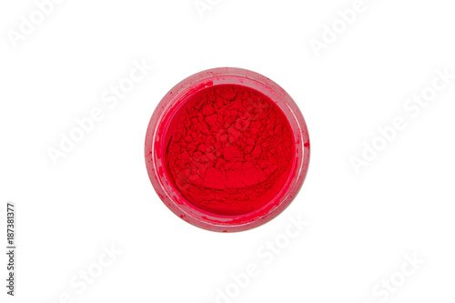 Red pigment for manicure. Beautiful bright red powder for summer, spring, nail design. Loose paint in a small glass jar on a white background.