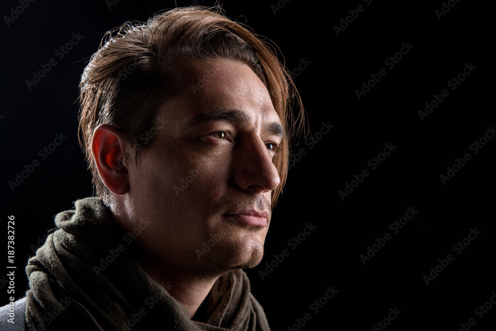 Lost in thoughts. Serious young hopeless man is standing and looking aside thoughtfully. Isolated background and copy space in right side Lost in thoughts. Serious young hopeless man is standing and looking aside thoughtfully. Isolated background and copy space in right side