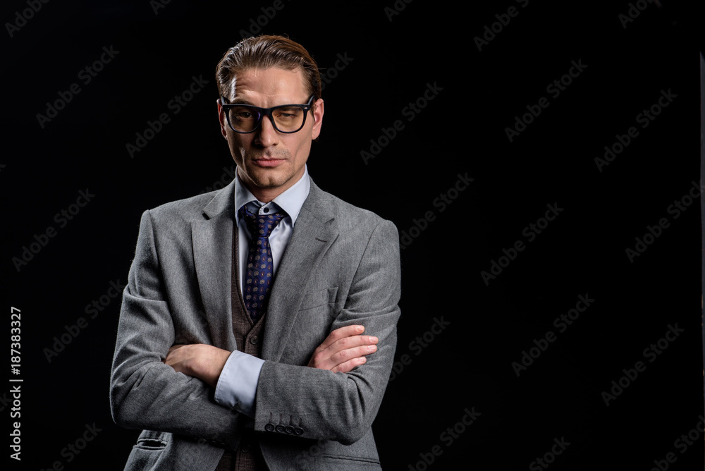 Formidable manager. Portrait of confident young stylish businessman in official clothes is standing with crossed hands. He is looking at camera seriously. Isolated with copy space Formidable manager. Portrait of confident young stylish businessman in official clothes is standing with crossed hands. He is looking at camera seriously. Isolated with copy space