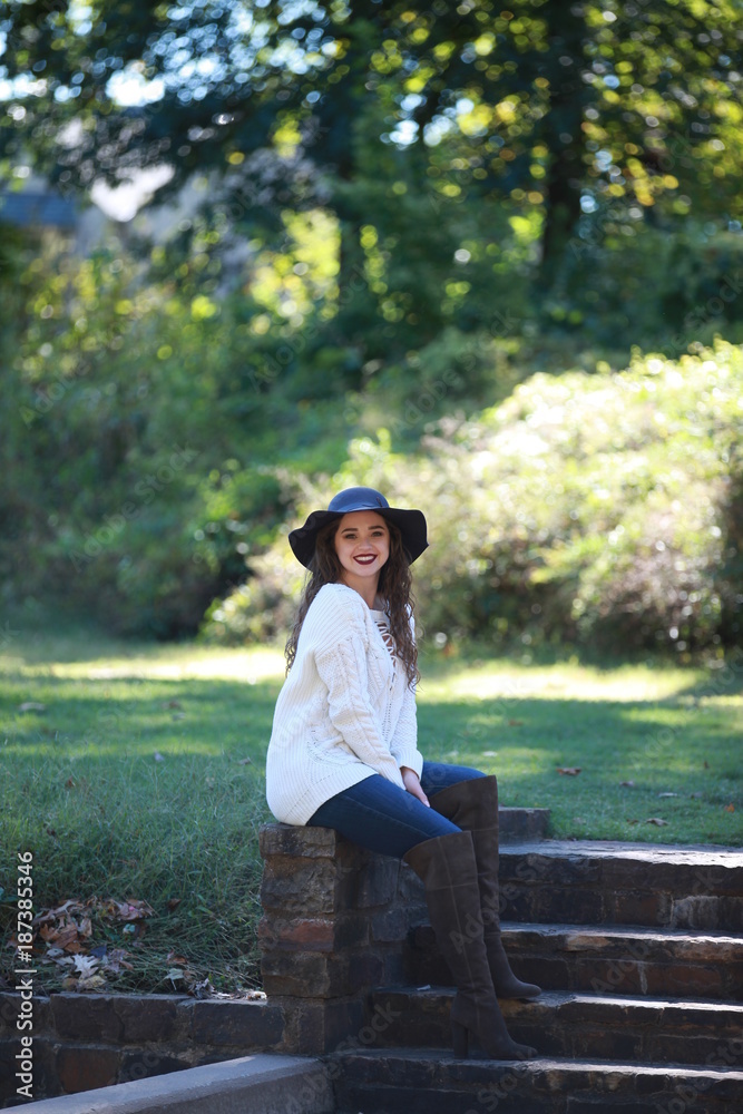 Fototapeta premium Cheerful woman sitting in park