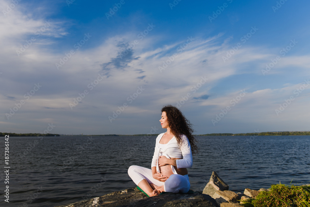 Meditating pregnant woman in lotus position.
