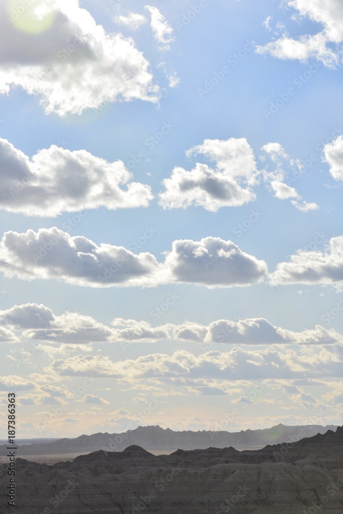Obraz premium Sunny skies behind puffy clouds