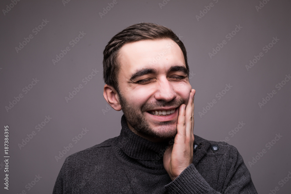 Closeup portrait of young man with tooth ache crown problem about to cry from pain touching outside mouth with hand, isolated on dark background. Negative human emotion facial expression feeling Closeup portrait of young man with tooth ache crown problem about to cry from pain touching outside mouth with hand, isolated on dark background. Negative human emotion facial expression feeling