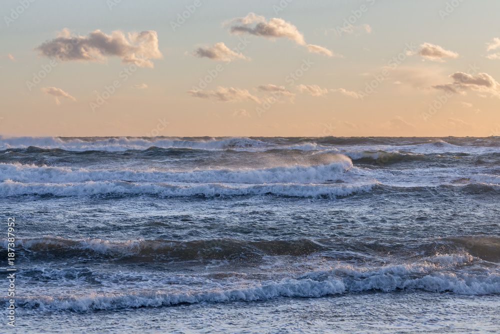Fototapeta premium vague agitées au coucher de soleil orange