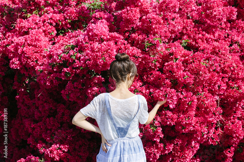 Woman standing in front of massive bougainvillea flower bush photo
