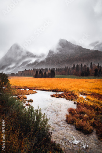 Alpen in herbstlicher Atmosphäre mit Fluss im Vordergrunf photo