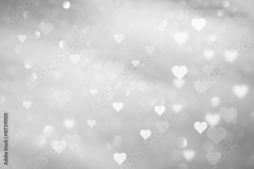 Beautiful abstract white colored hearts on blurry silver bokeh background. 