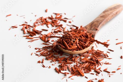 Fotografie Pieces of sandalwood on a wooden spoon on a white background