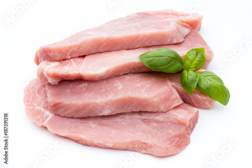 Fresh pork fillet with basil on a white background.