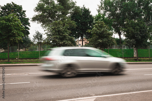 A white car at high speed crosses a pedestrian crossing, a motion blur effect © Jevgenij