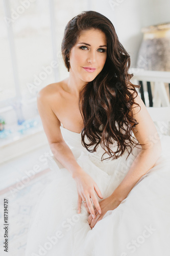 Beautiful Brunette Bride Sitting with Hands in Lap photo