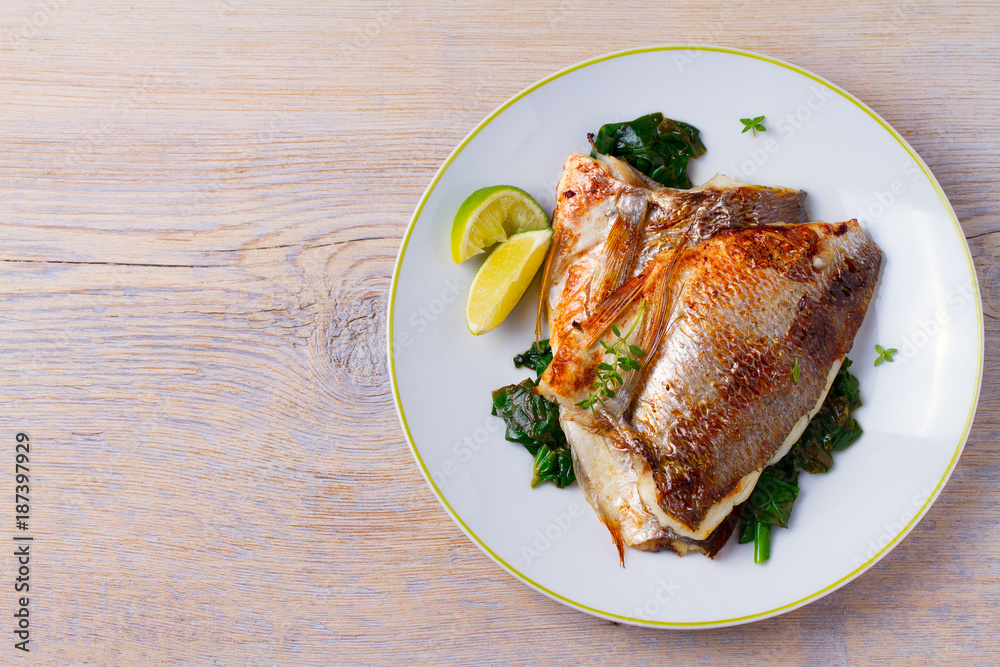 Dorado or dorada fish fillet with spinach, thyme and lime. View from above, top, horizontal Dorado or dorada fish fillet with spinach, thyme and lime. View from above, top, horizontal