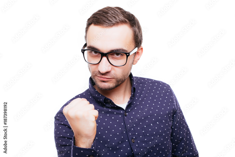 Portrait of an angry furious man threatening with a fist isolated over white background
