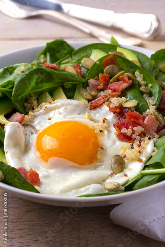 Fried egg with bacon  quinoa  avocado  spinach and pumpkin seeds for breakfast