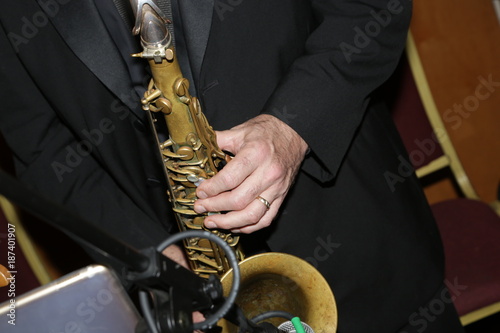 Musician playing brown saxophone in black tux during and event 