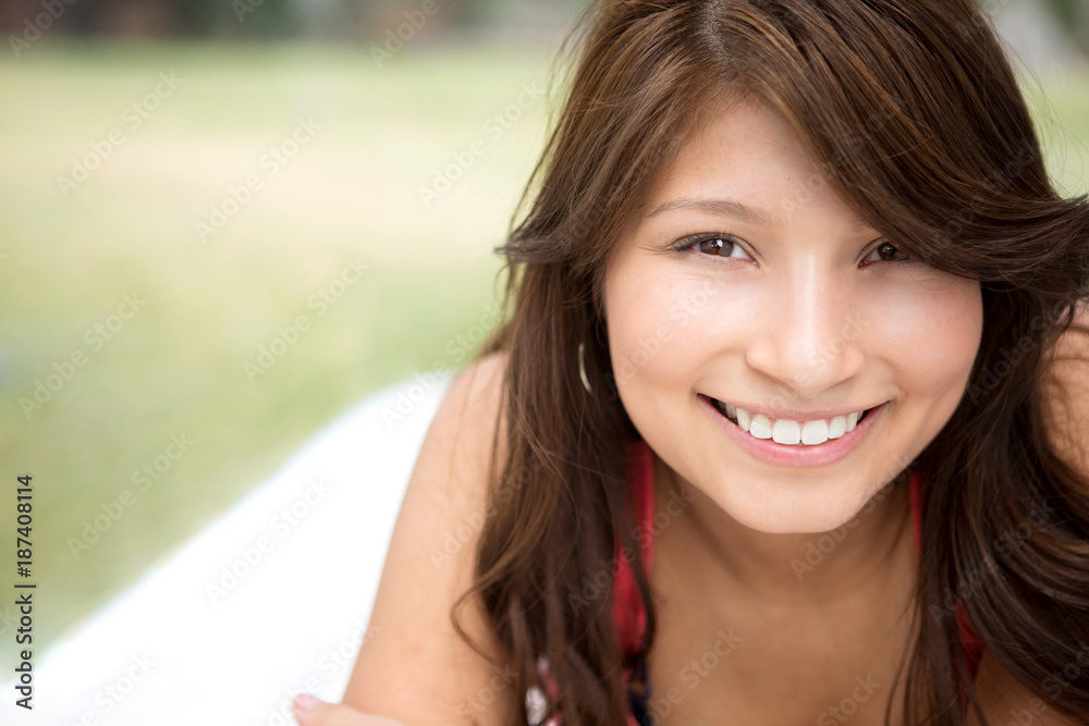 Fototapeta premium Young Hispanic girl smiling outside.