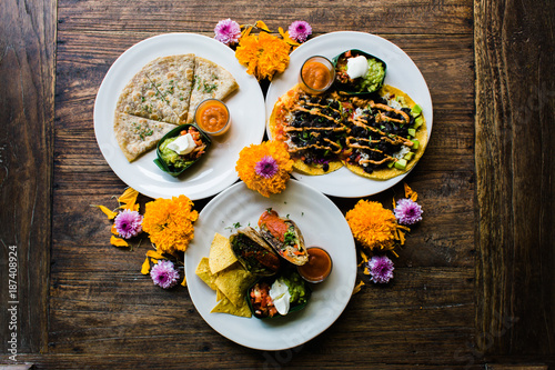 Overhead view of Mexican food decorated with flowers on table photo
