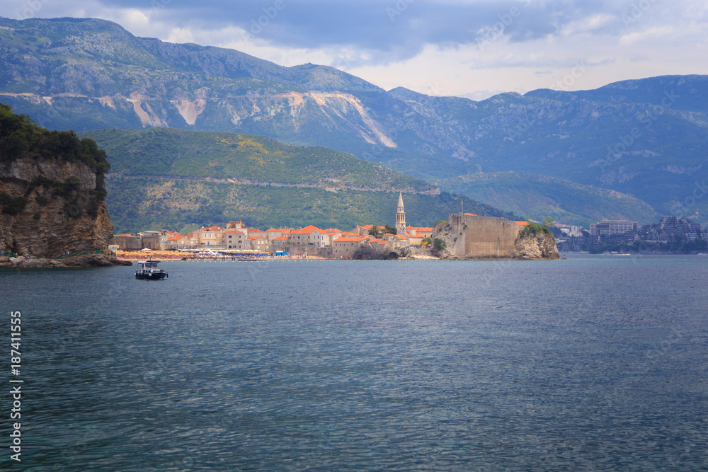 view from the sea to the old town of Budva on background of green mountains