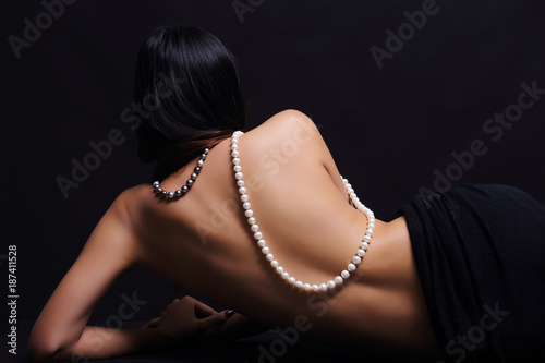 Portrait of beautiful nude long straight black hair woman with pearl necklace photo